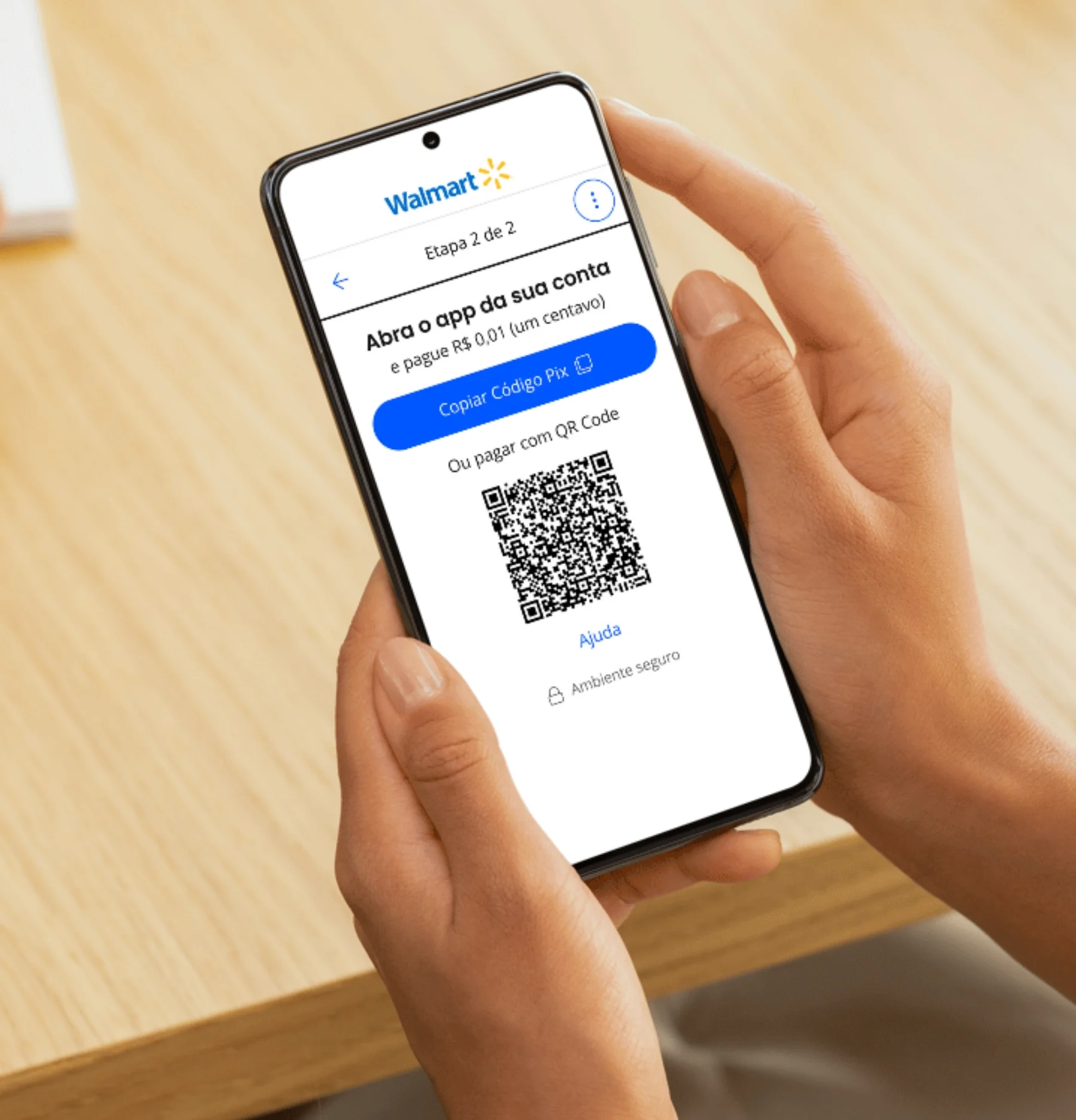 Mãos segurando um celular na tela Abra o app da sua conta, com o botão Copiar Código Pix e o QR Code
